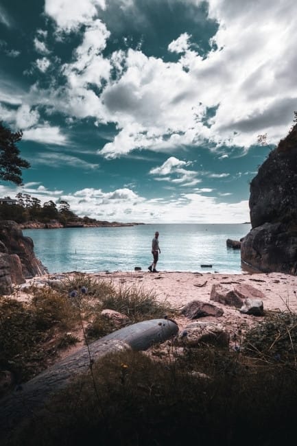 Stunning landscapes in Telemark Man is walking on the rocky beach near Langesund